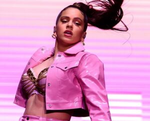 Rosalía actuando en un espectáculo musical con vestuario rosa brillante