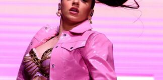 Rosalía actuando en un espectáculo musical con vestuario rosa brillante
