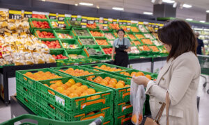 Mujer comprando caquis en la sección de frutas del Mercadona.