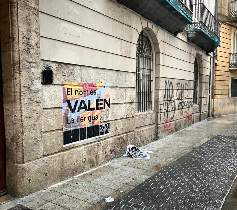 Pared con un cartel que dice El nom és VALEN en una calle
