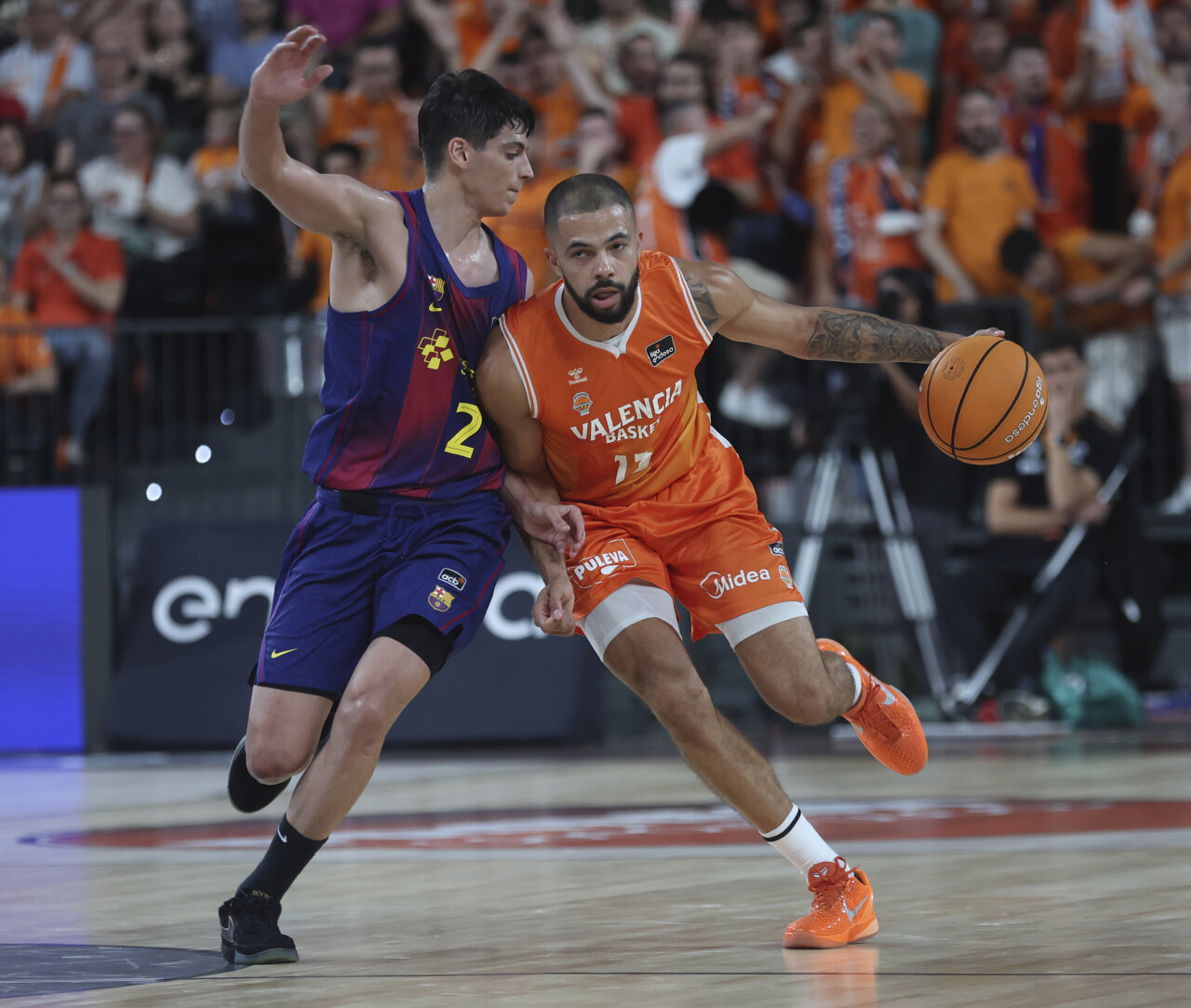 Jugadores de Valencia Basket y FC Barcelona compiten en un partido de baloncesto.