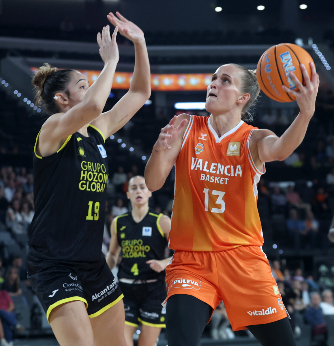 Jugadora de Valencia Basket lanzando a canasta en un partido competitivo.