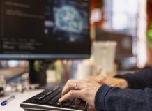 Persona escribiendo en un teclado mientras trabaja en inteligencia artificial