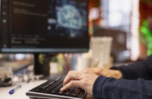 Persona escribiendo en un teclado mientras trabaja en inteligencia artificial