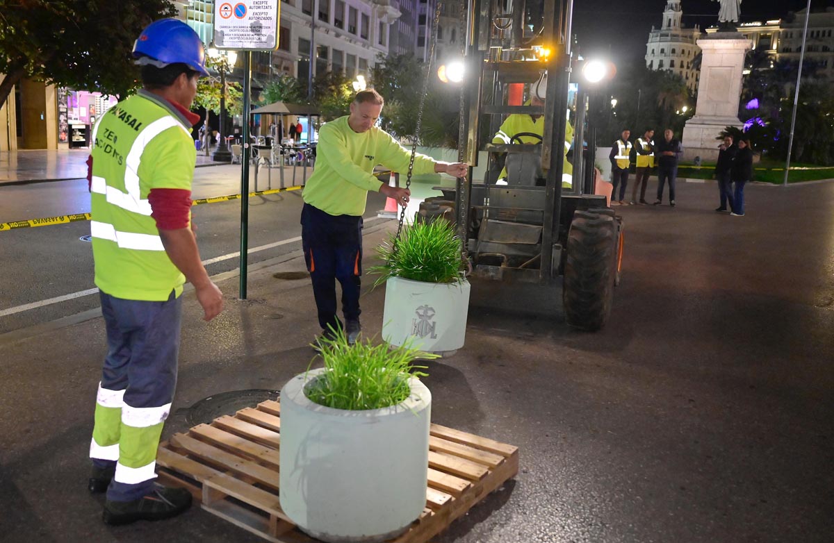 Trabajadores instalando nuevos maceteros en la plaza del Ayuntamiento de Valencia