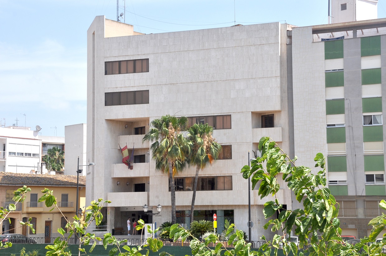 Edificio del Ayuntamiento de Paiporta con palmeras en primer plano