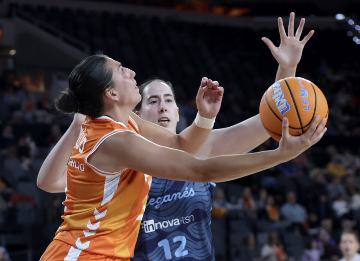 Jugadora de Valencia Basket intenta anotar mientras es defendida por rival.