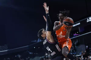Jugador de Valencia Basket intentando anotar contra un defensor de Paris Basketball
