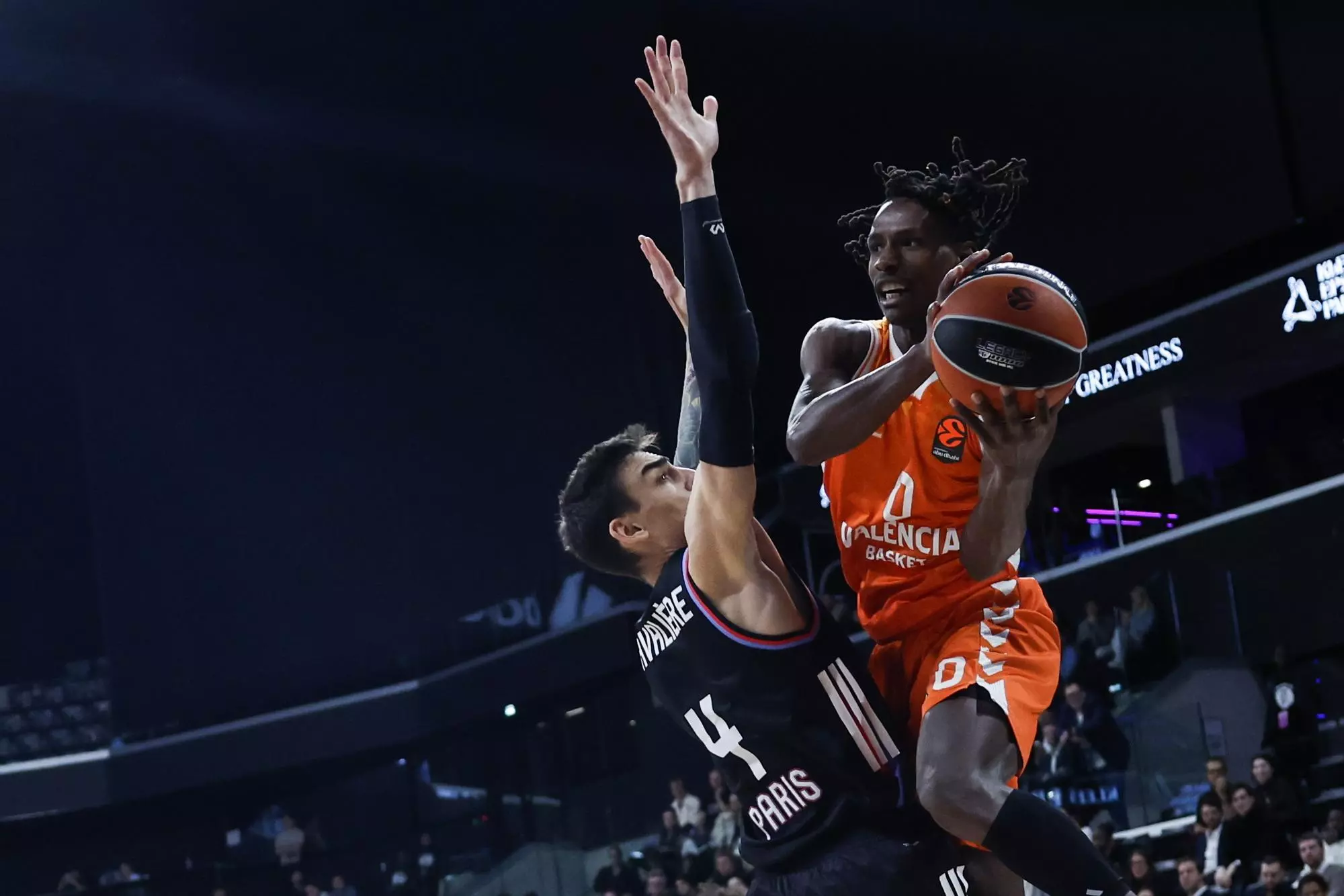 Jugador de Valencia Basket intentando anotar contra un defensor de Paris Basketball
