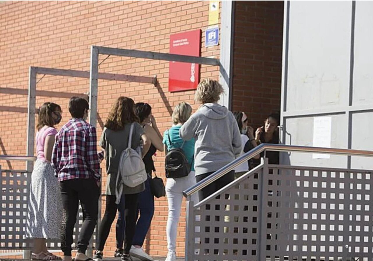 Grupo de personas esperando en la entrada del centro de salud La Coma en Paterna.