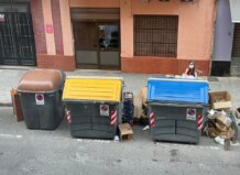 Multas de hasta 3.000 euros por ensuciar la vía pública tras la reforma de la Ordenanza de Limpieza en València Contenedores de basura en una calle de València con residuos alrededor.