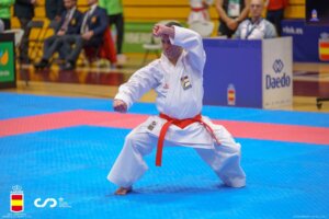 Deportista realizando una técnica de karate en competición.