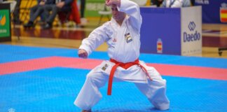 Deportista realizando una técnica de karate en competición.