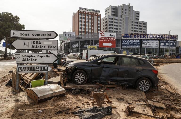 Zona comercial en Alfafar con daños tras la DANA y un coche volcado