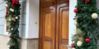 Puerta del ayuntamiento decorada con adornos navideños en Meliana