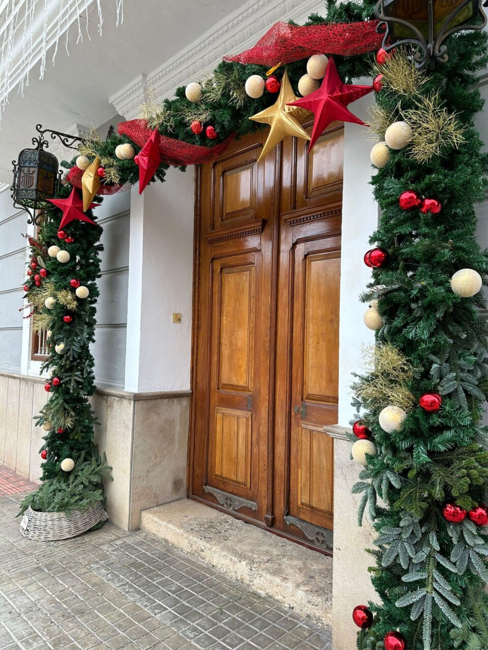 Puerta del ayuntamiento decorada con adornos navideños en Meliana
