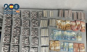 Cápsulas de medicamento anticonvulsivo y billetes de euro en mesa