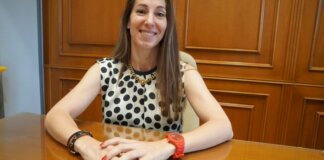 Yolanda Andrés posando en un entorno de oficina con una blusa de lunares