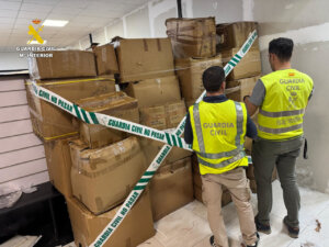 Agentes de la Guardia Civil inspeccionan cajas de falsificaciones en Manises