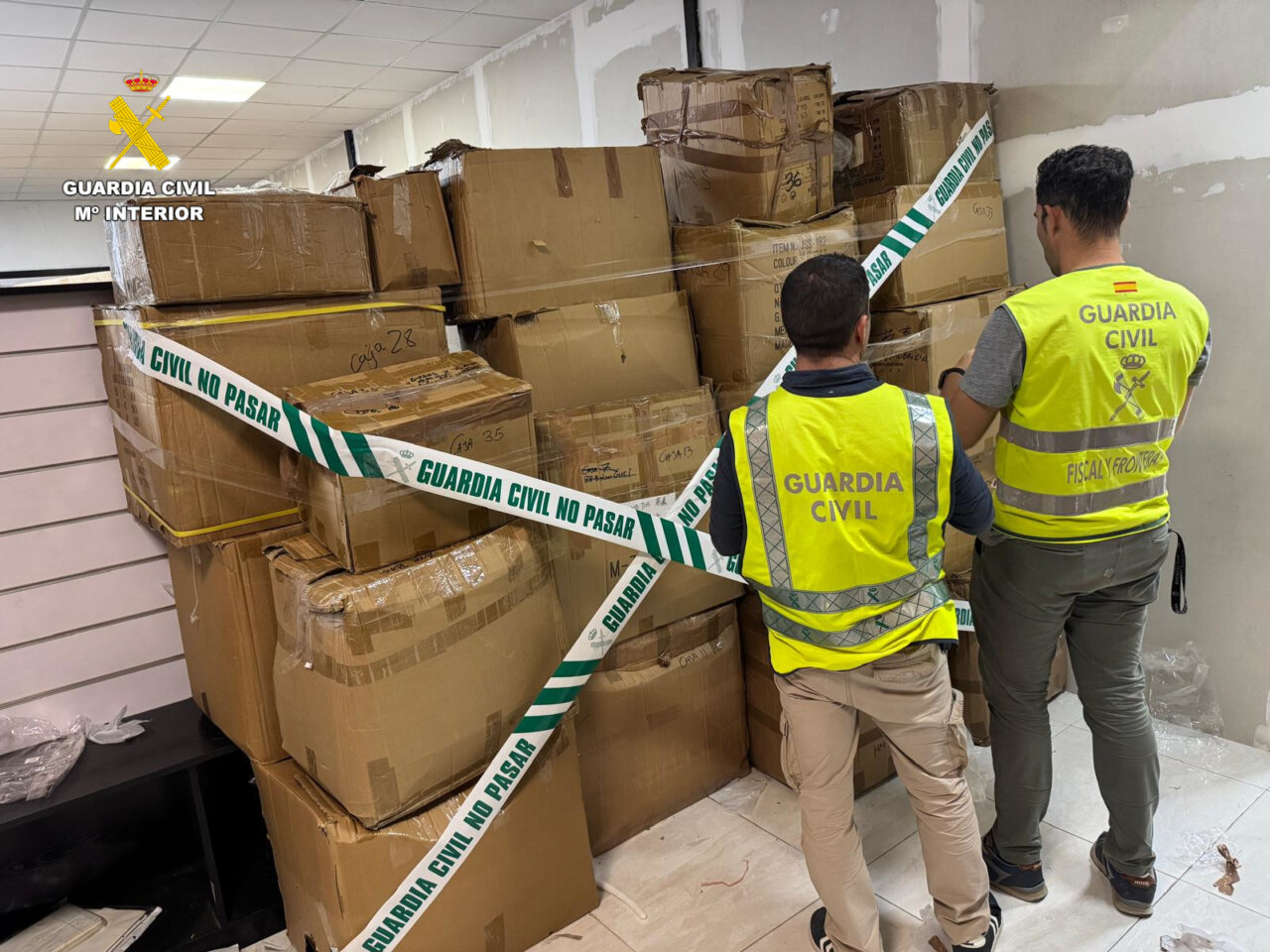 Agentes de la Guardia Civil inspeccionan cajas de falsificaciones en Manises
