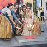 Cuatro mujeres en trajes tradicionales en una ceremonia con fuego.