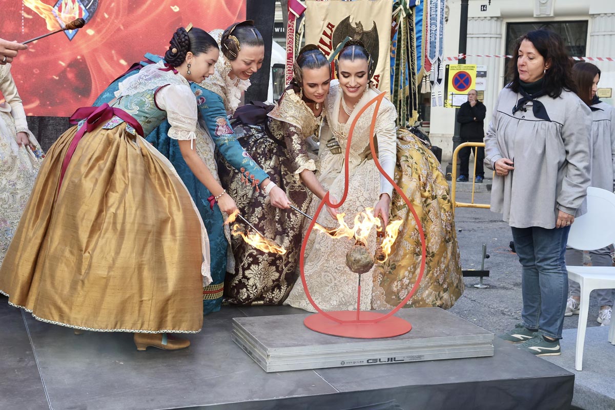 Cuatro mujeres en trajes tradicionales en una ceremonia con fuego.