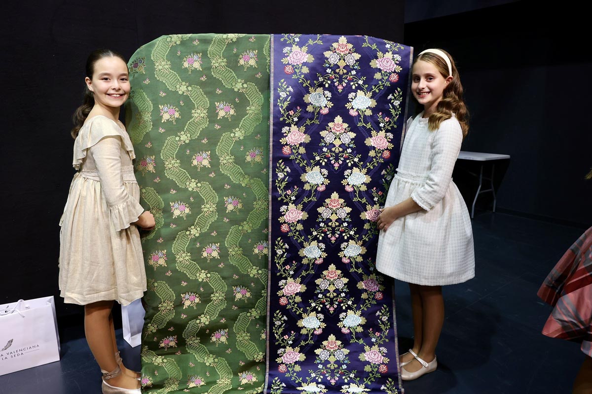 Niñas sosteniendo telas de seda en la presentación de la Corte de Honor Infantil.