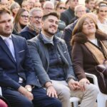 Asistentes a un homenaje con expresiones de emoción y alegría.