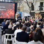 Ceremonia de homenaje a Manolo Algarra con público y presentación en pantalla.