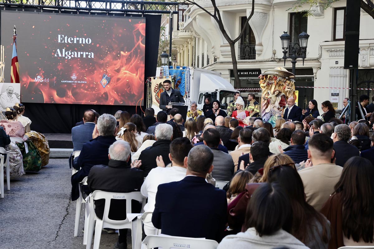 Ceremonia de homenaje a Manolo Algarra con público y presentación en pantalla.