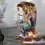 Escultura en llamas durante homenaje a Manolo Algarra con humo y fuegos artificiales.