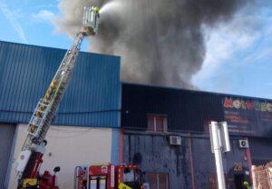 Bomberos controlando un incendio en un desguace de motos en Alboraya