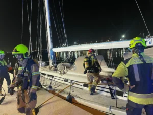 Bomberos trabajando en un velero en el Club Náutico de Valencia