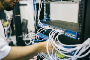 Técnico ajustando cables en un equipo de red para eventos