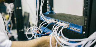 Técnico ajustando cables en un equipo de red para eventos