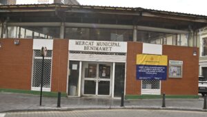 Fachada del Mercat Municipal de Benimàmet con cartel de obras para la Policía Local