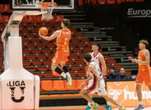 Jugador del Valencia Basket realizando un mate durante un partido emocionante.