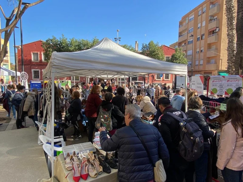 Mercado solidario en Manises con muchas personas comprando objetos perdidos.