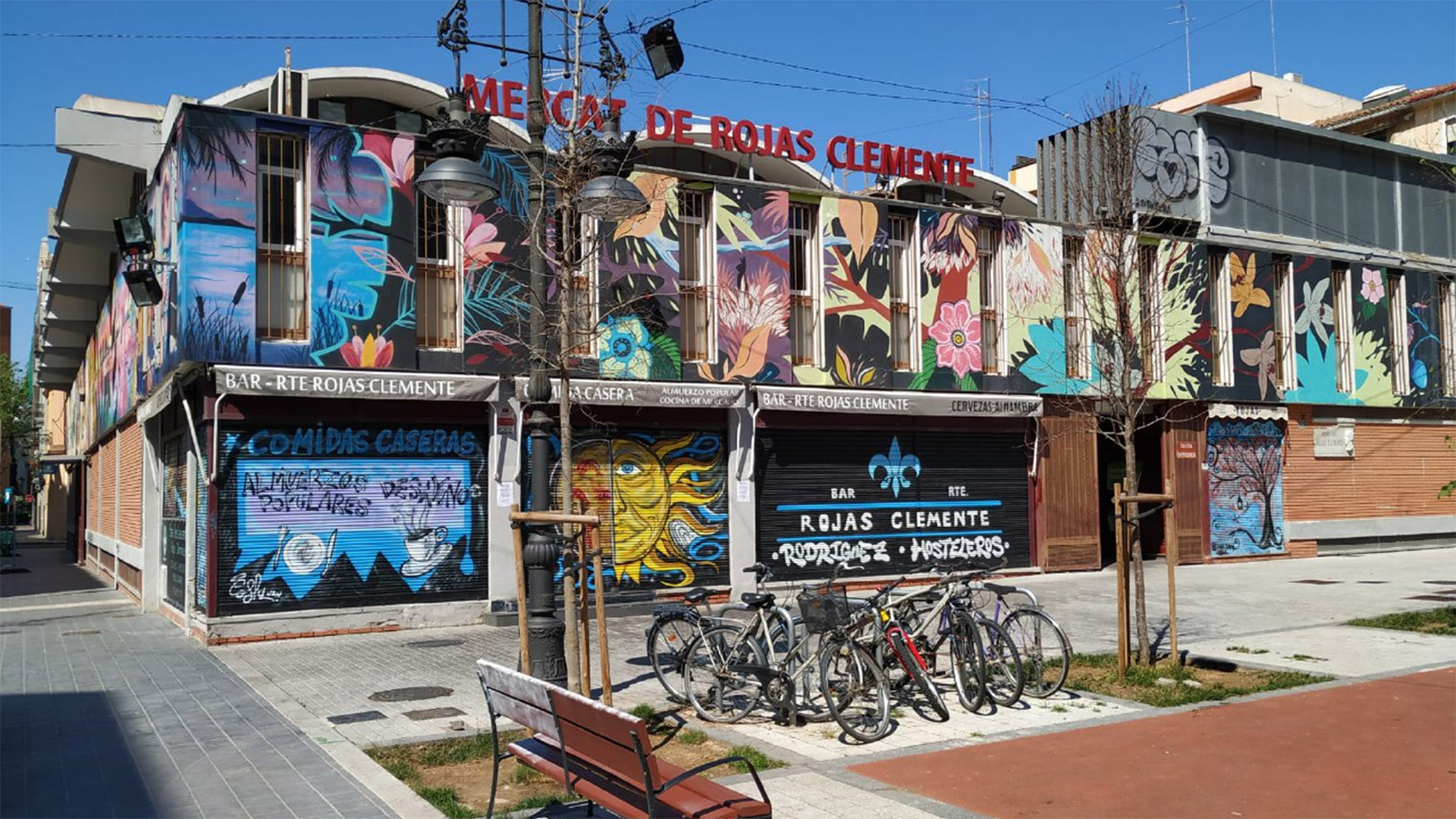Fachada del Mercat de Rojas Clemente en Valencia con murales coloridos.