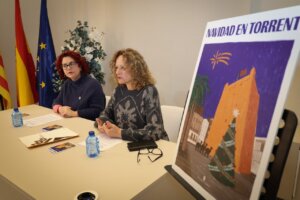 Presentación de la programación navideña en Torrent con dos mujeres y un cartel