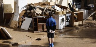 La Generalitat realizará un recuento de personas sin hogar en 12 municipios afectados por la DANA Niño observando escombros tras la DANA en Valencia