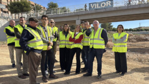 Grupo de personas en chalecos amarillos frente al nuevo puente de Paiporta