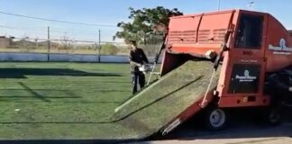 Trabajador retirando la antigua gespa del campo de futbol en Silla