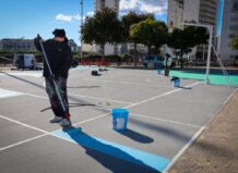 Trabajador pintando nuevas pistas de Street Basket en Torrent