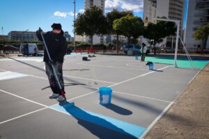 Trabajador pintando nuevas pistas de Street Basket en Torrent
