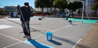 Trabajador pintando nuevas pistas de Street Basket en Torrent