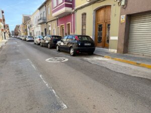 Vista de la calle Colón en Alfafar con coches aparcados y edificios