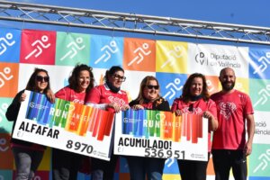 Grupo de participantes en la XI RunCáncer Alfafar mostrando carteles de recaudación