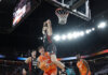 Jugadores de Valencia Basket y Girona en un emocionante partido de baloncesto.