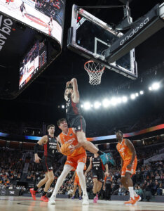 Jugadores de Valencia Basket y Girona en un emocionante partido de baloncesto.